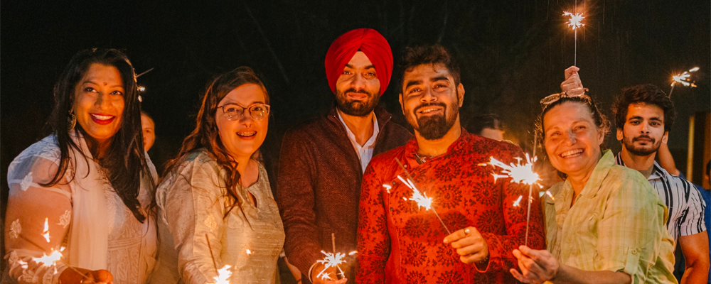 NUSU hosts Diwali Celebrations - Sparklers are lit and a crowd is smiling.